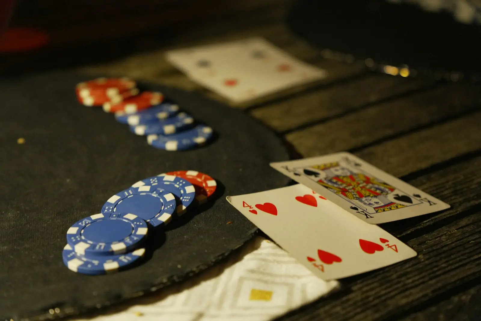 Chip poker dan kartu remi di atas meja gelap