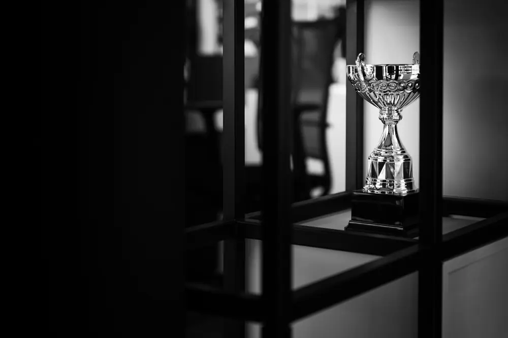 Piala perak di atas meja sebagai simbol kompetisi